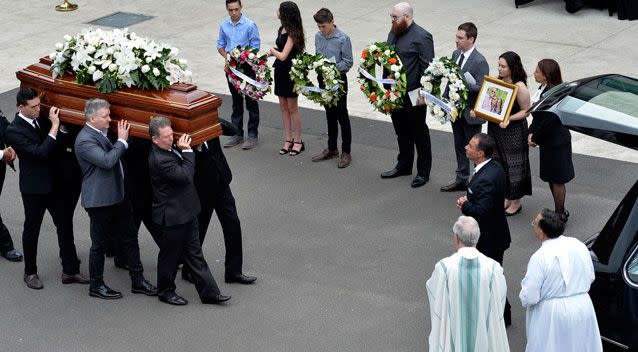 Loved ones were seen holding wreaths and photos as the caskets were walked out. Photo: AAP