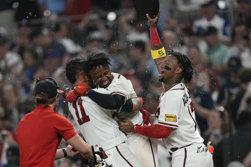 Atlanta Braves' Ozzie Albies, center, celebrates with Orlando Arcia (11) and Ronald Acuna Jr. after driving in the winning run with a sacrifice fly against the Los Angeles Dodgers during the ninth inning of a baseball game Wednesday, May 24, 2023, in Atlanta. (AP Photo/John Bazemore)