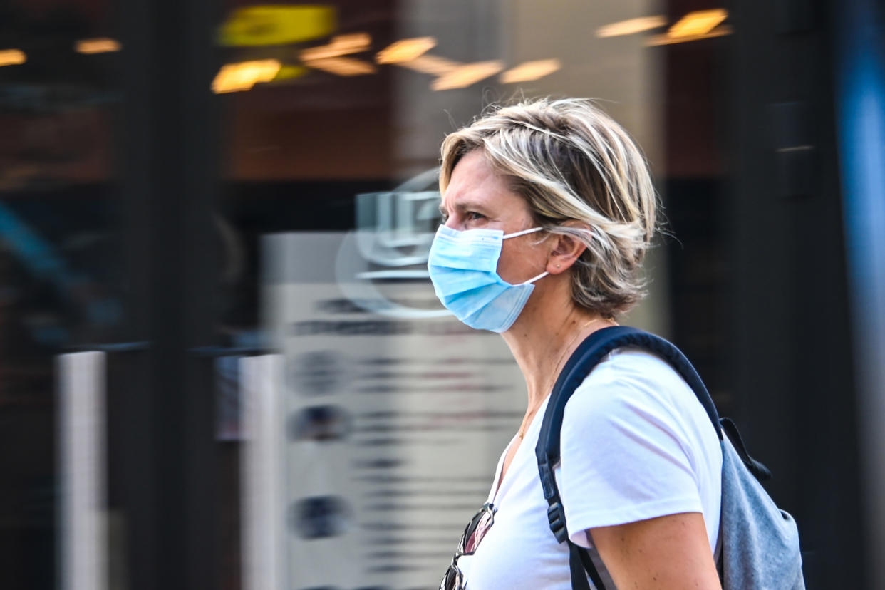 A woman wearing a protective mask walks on a street in Lille, northern France, on July 30, 2020, as The Nord Prefecture announced, the reinforcement of the health measures at a local level to attempt to halt the rising cases of coronavirus Covid-19, which have been seen in the region during the past two weeks. - In a discussion between the French Health Minister, The Nord Prefet and Nord Regional Health Agency director (ARS) on July 29, the possibility of making the wearing of protective masks compulsory outside "due to the proximity with Belgium" was spoken of in an effort to halt the rise of coronavirus cases. (Photo by DENIS CHARLET / AFP) (Photo by DENIS CHARLET/AFP via Getty Images)