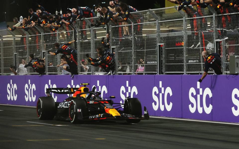 Race winner Sergio Perez of Mexico driving the (11) Oracle Red Bull Racing RB19 passes his team celebrating on the pitwall during the F1 Grand Prix of Saudi Arabia at Jeddah Corniche Circuit on March 19, 2023 in Jeddah, Saudi Arabia - Lars Baron/Getty Images