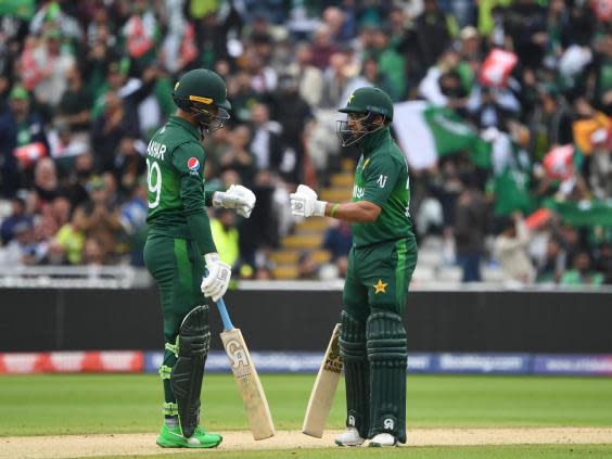 Imam-ul-Haq (R) and teammate Fakhar Zaman touch gloves after a boundary (Getty)