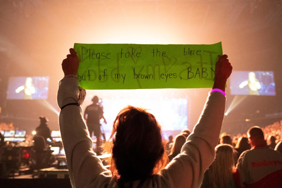 A fan holds up a sign with lyrics to Keith Urban’s song Brown Eyes Baby during a concert Friday night at Nationwide Arena.