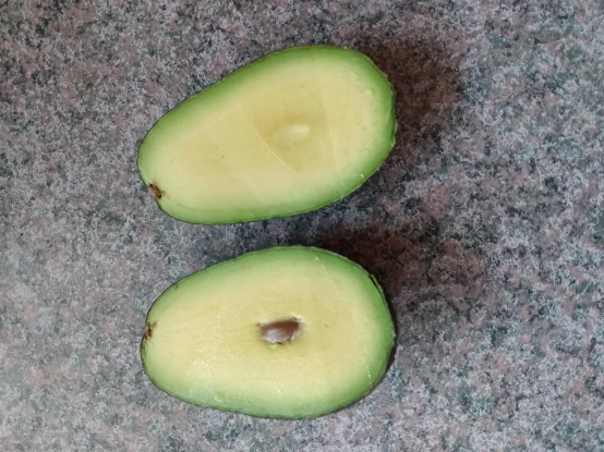 An avocado with a small seed in the middle
