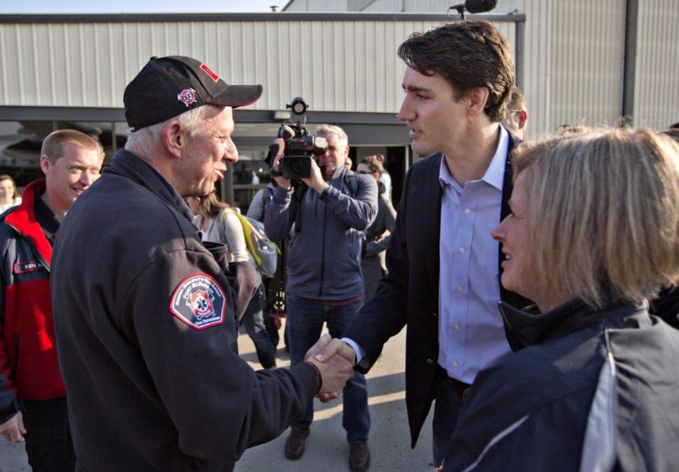 Prime Minister Justin Trudeau shakes hands with Fort McMurray fire chief Darby Allen as Alberta Premier Rachel Notley (right) looks on in Edmonton, Friday, May 13, 2016. THE CANADIAN PRESS/Jason Franson