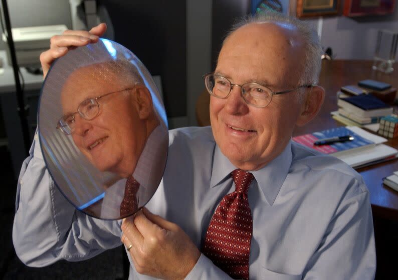 Intel Corp. co-founder Gordon Moore holds up a silicon wafer at Intel headquarters in Santa Clara, Calif., Wednesday, March 9, 2005. This is the 40th anniversary of "Moore's Law". Moore saw that the number of components on an integrated circuit had doubled every year and figured that rate would continue for a decade as transistors were made smaller. He saw that the per-component costs would fall as manufacturing improved. (AP Photo/Paul Sakuma)