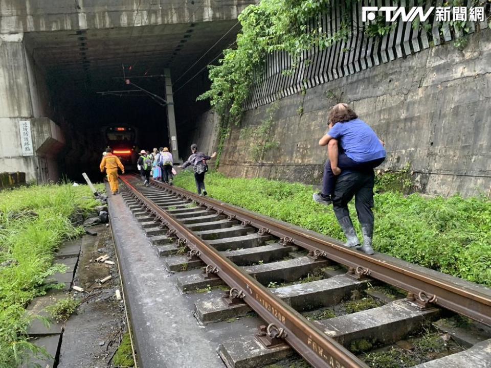 由於事發突然，列車上的旅客只能摸黑下車，沿著腿軌步行疏散。（圖／翻攝畫面）