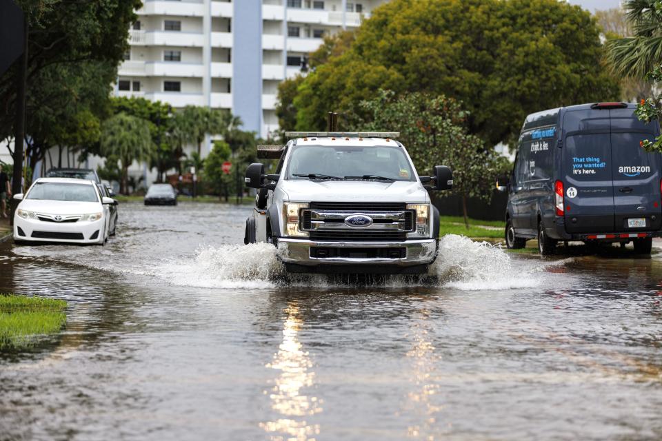 A tow truck goes through the flooded road cause by heavy rains at North Bay Rd and 179th Dr. in Sunny Isles Beach, Fla., Wednesday, April 12, 2023. A torrential storm bought heavy showers, gusty winds and thunderstorms to South Florida on Wednesday and prompted the closure of Fort Lauderdale-Hollywood International Airport and the suspension of high-speed commuter rail service in the region.(David Santiago/Miami Herald via AP)