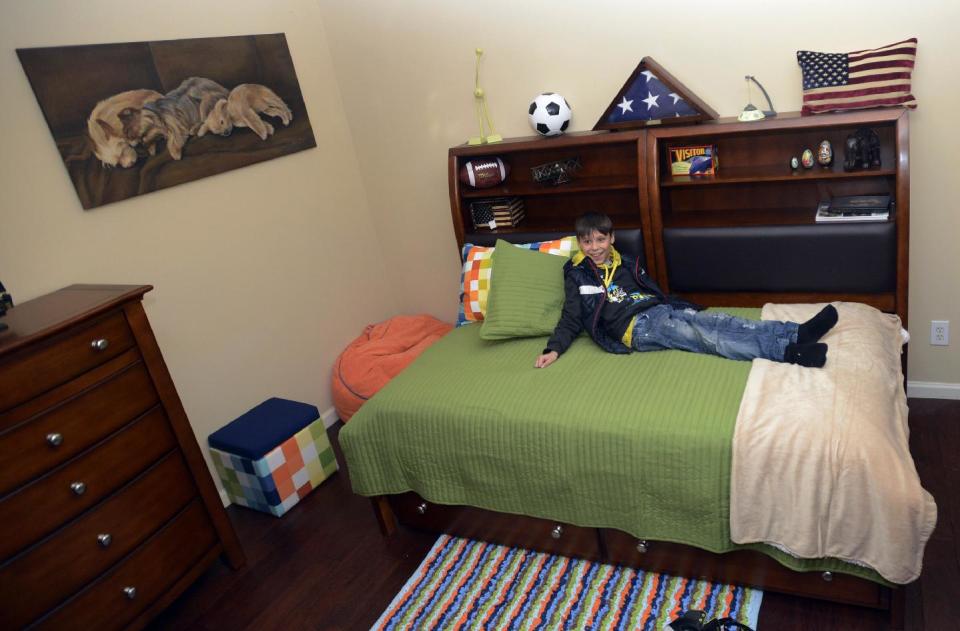 In this photo from Feb. 23, 2014, Max Bundy tries out his new bed and new home in Montgomery, Ala. David Bundy and three of their newly adopted four children, Karina, Max and Alla, arrived home from the Ukraine on Sunday. While Lisa Bundy remains in Ukraine until the adoption of their daughter Nastia is finalized. (AP Photo/Montgomery Advertiser, Amanda Sowards) NO SALES.