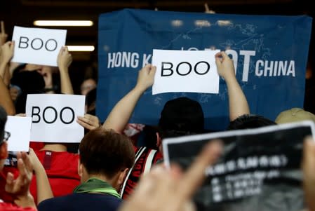Soccer fans hold signs in support of anti-government protesters at a football World Cup qualifier match between Hong Kong and Iran, at Hong Kong Stadium