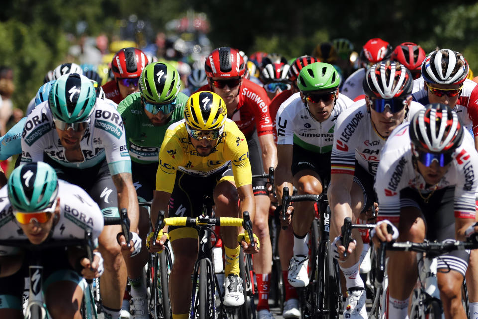 The pack rides with France's Julian Alaphilippe wearing the overall leader's yellow jersey during the tenth stage of the Tour de France cycling race over 217 kilometers (135 miles) with start in Saint-Flour and finish in Albi, France, Monday, July 15, 2019. (AP Photo/ Christophe Ena)