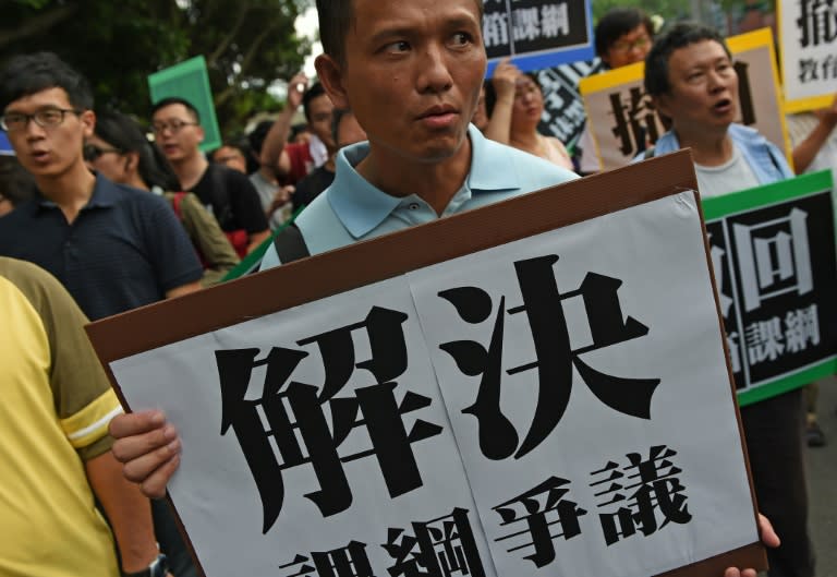 An activist holds a placard that reads, "Fix the disputed curriculum" during a demonstration by Taiwanese students and activists against the island's China-centric curriculum changes, in Taipei on August 2, 2015