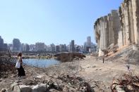 A woman walks on rubble at the site of last year's Beirut port blast, in Beirut