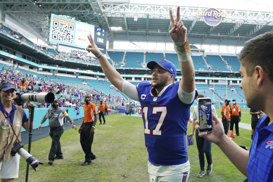 Buffalo Bills quarterback Josh Allen (17) raises his arms at the end of an NFL football game against the Miami Dolphins, Sunday, Sept. 19, 2021, in Miami Gardens, Fla. The Bills defeated the Dolphins 35-0. (AP Photo/Hans Deryk)