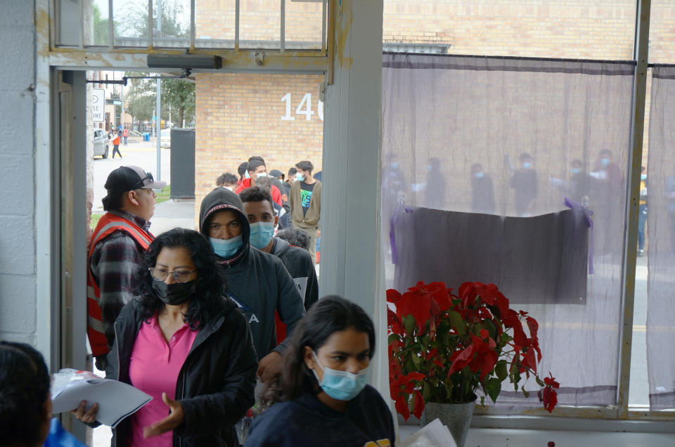 People line up inside and outside the migrant welcome center across from the bus station in Brownsville, Texas, on Friday, Dec. 16, 2022. Volunteers from Team Brownville at the center handed out food and necessities, like toothpaste and socks, to migrants that U.S. officials detained and released across the street. Most of Friday's group said they were from Nicaragua, with a few from the Dominican Republic. (AP Photo/Giovanna Dell'Orto)