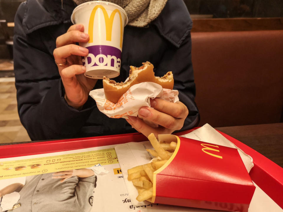 A person eating McDonald's burger and fries.