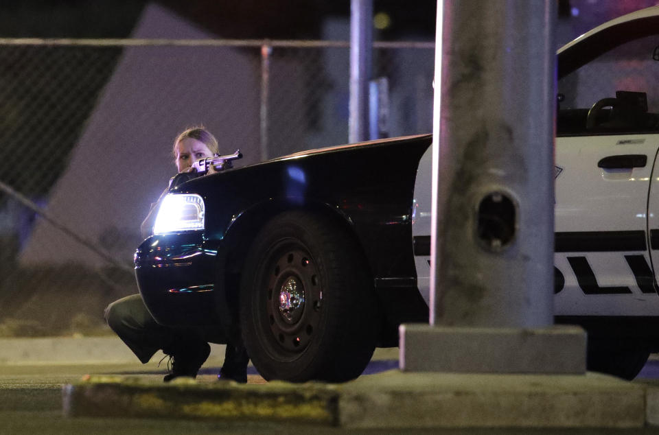 <p>A police officer takes cover behind a police vehicle during a shooting near the Mandalay Bay resort and casino on the Las Vegas Strip, Oct. 1, 2017, in Las Vegas. (Photo: John Locher/AP) </p>