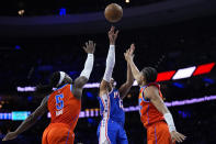 Philadelphia 76ers' Tobias Harris, center, goes up for a shot against Oklahoma City Thunder's Aaron Wiggins, right, and Luguentz Dort during the first half of an NBA basketball game, Tuesday, April 2, 2024, in Philadelphia. (AP Photo/Matt Slocum)