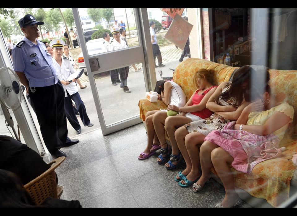 Chinese police watch over a group of massage girls suspected of prostitution during a June 21, 2011, raid in Beijing, part of a vice crackdown ahead of celebrations for the founding of the Chinese Communist Party 90 years ago. Rapid social and economic changes have made China "prone to corruption." and the ruling Communist Party faces a major challenge stamping out deep-rooted official graft, an official said on June 22. (Photo credit: STR/AFP/Getty Images)