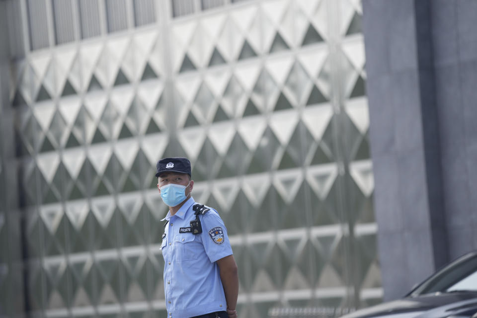 A policeman wearing a face mask stands guard outside a detention center where Dominic Barton, Ambassador of Canada to China will meet Canadian Michael Spavor, in Dandong, China, Wednesday, Aug. 11, 2021. A Chinese court has sentenced Michael Spavor to 11 years on spying charges in case linked to Huawei. (AP Photo/Ng Han Guan)