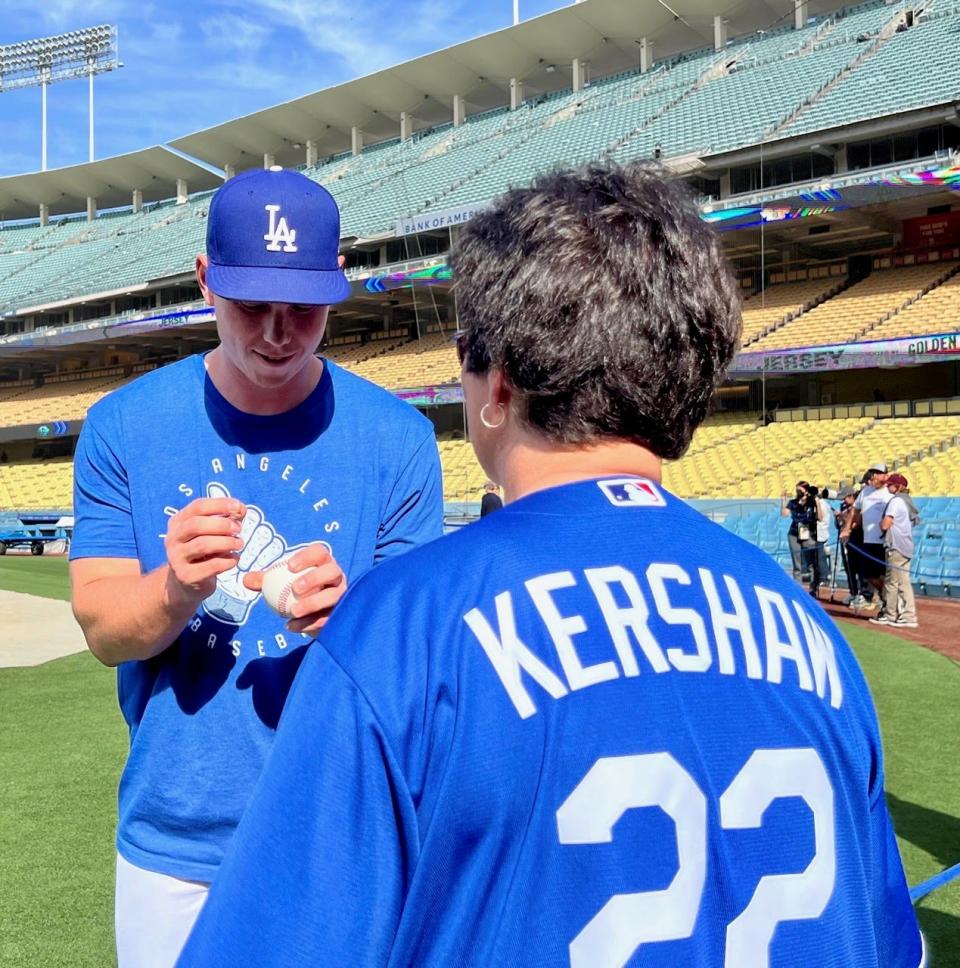 Dodgers catcher Will Smith signs an autograph for Palm Springs resident Denise Goolsby, wearing a Clayton Kershaw jersey, before she threw out the ceremonial first pitch at the Dodgers game Thursday.