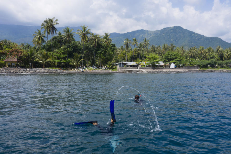 Local villager and fisherman Made Partiana and a local villager search for fish off the coast of Les, Bali, Indonesia, on April 10, 2021. (AP Photo/Alex Lindbloom)