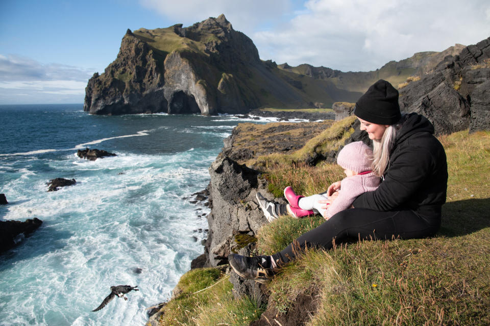 Sandra Sif Sigvardsd&oacute;ttir releases a puffling from the cliffs with her 2-year-old daughter Eva&nbsp;Berglind. (Photo: Jennifer Adler)