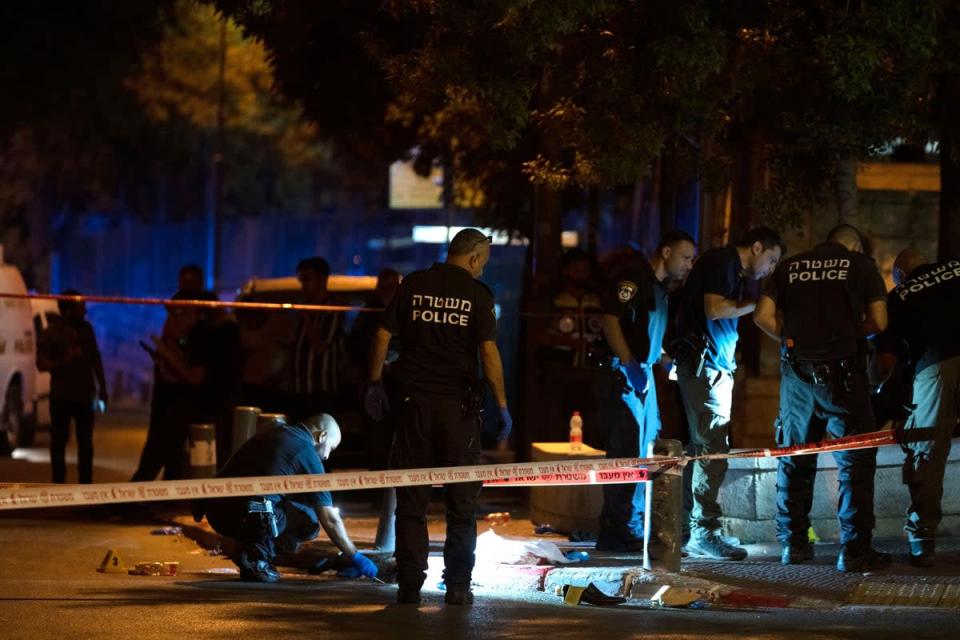 Israeli police crime scene investigators work at the scene of a shooting (AP)