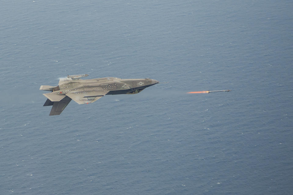A Lockheed Martin F-35 flying inverted and firing a missile.