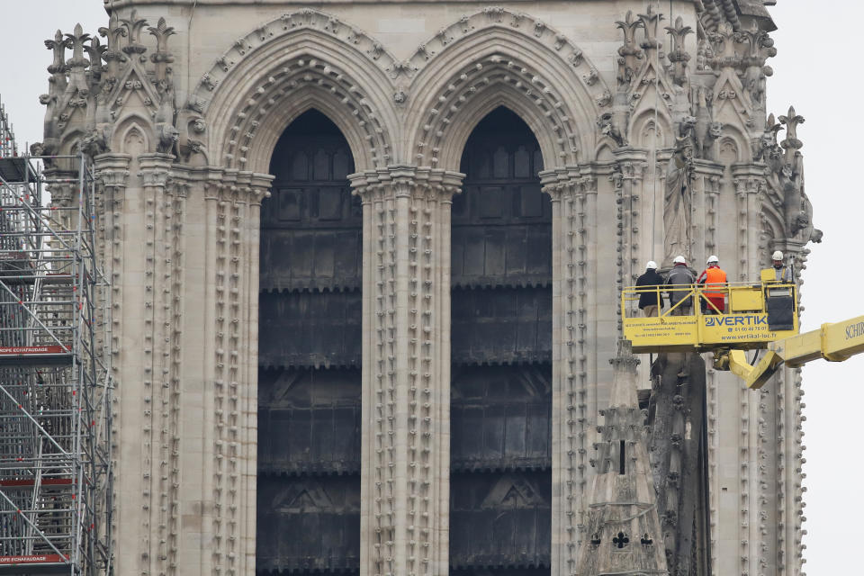 Una grúa levanta a expertos mientras inspeccionan la dañada catedral Notre Dame tras el incendio en París, el martes 16 de abril de 2019. (AP Foto/Christophe Ena)