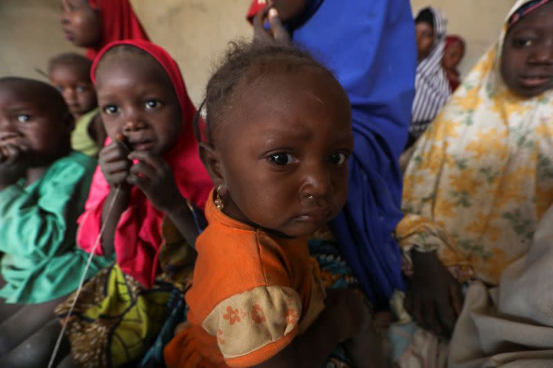 Children who are displaced due to attacks by bandits in a village, look on in a shelter for displaced people in Gusau
