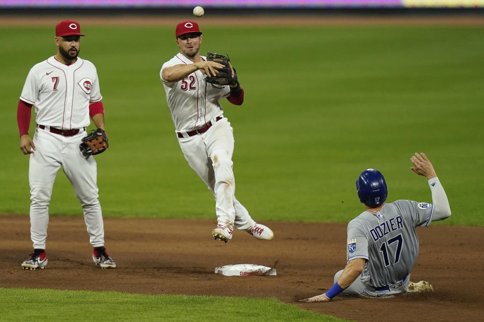 Cincinnati Reds second baseman Kyle Farmer (52) turns a double play during the seventh inning of a baseball game against the Kansas City Royals at Great American Ballpark in Cincinnati, Tuesday, Aug. 11, 2020. (AP Photo/Bryan Woolston)