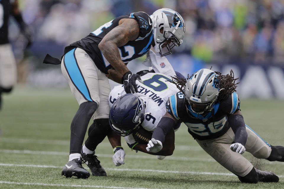 Seattle Seahawks running back Kenneth Walker III is tackled by Carolina Panthers safety Vonn Bell (24) and cornerback Donte Jackson during the second half of an NFL football game Sunday, Sept. 24, 2023, in Seattle. (AP Photo/John Froschauer)