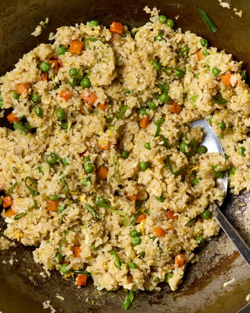 Fried rice in a wok with a metal spatula.