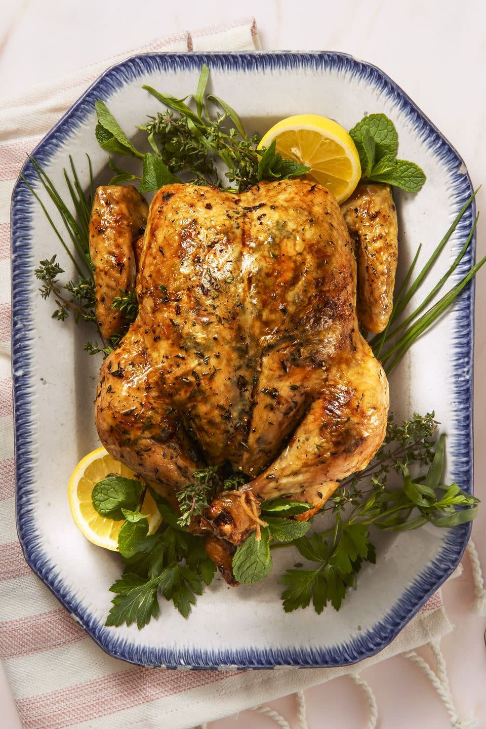 whole lemony herb roast chicken on a white plate