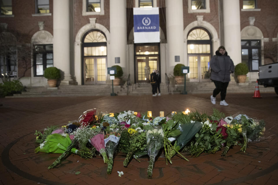A woman walks past a make-shift memorial for Tessa Majors inside the Barnard College campus, Thursday, Dec. 12, 2019, in New York. Majors, a 18-year-old Barnard College freshman from Virginia, was fatally stabbed in a park near the school's campus in New York City. (AP Photo/Mary Altaffer)