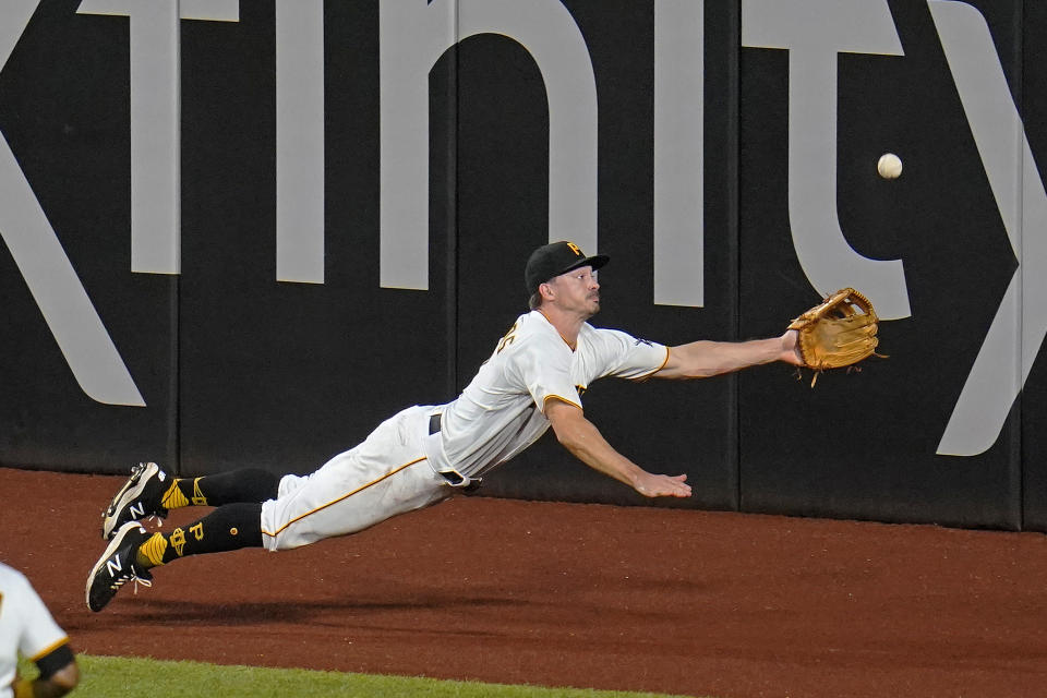 Pittsburgh Pirates left fielder Bryan Reynolds dives for but can't come up with a fly ball hit by Los Angeles Dodgers' Mookie Betts for an RBI triple during the fifth inning of a baseball game in Pittsburgh, Tuesday, June 8, 2021. (AP Photo/Gene J. Puskar)