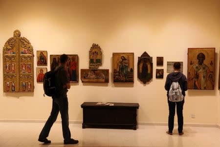 Tourists look at icons which were recovered by Cyprus after being stolen in the aftermath of Turkey's invasion in 1974, in a museum in Nicosia, Cyprus May 19, 2017. REUTERS/Yiannis Kourtoglou