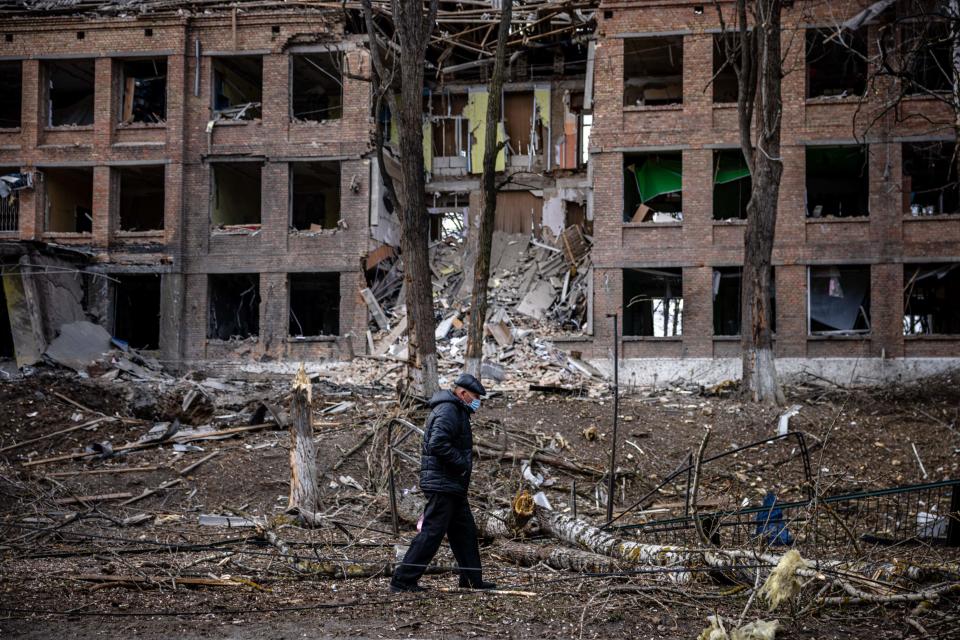 A man walks in front of a destroyed building after a Russian missile attack in the town of  Vasylkiv, near Kyiv, on February 27, 2022. Ukraine's foreign minister said on February 27, that Kyiv would not buckle at talks with Russia over its invasion, accusing President Vladimir Putin of seeking to increase "pressure" by ordering his nuclear forces on high alert.