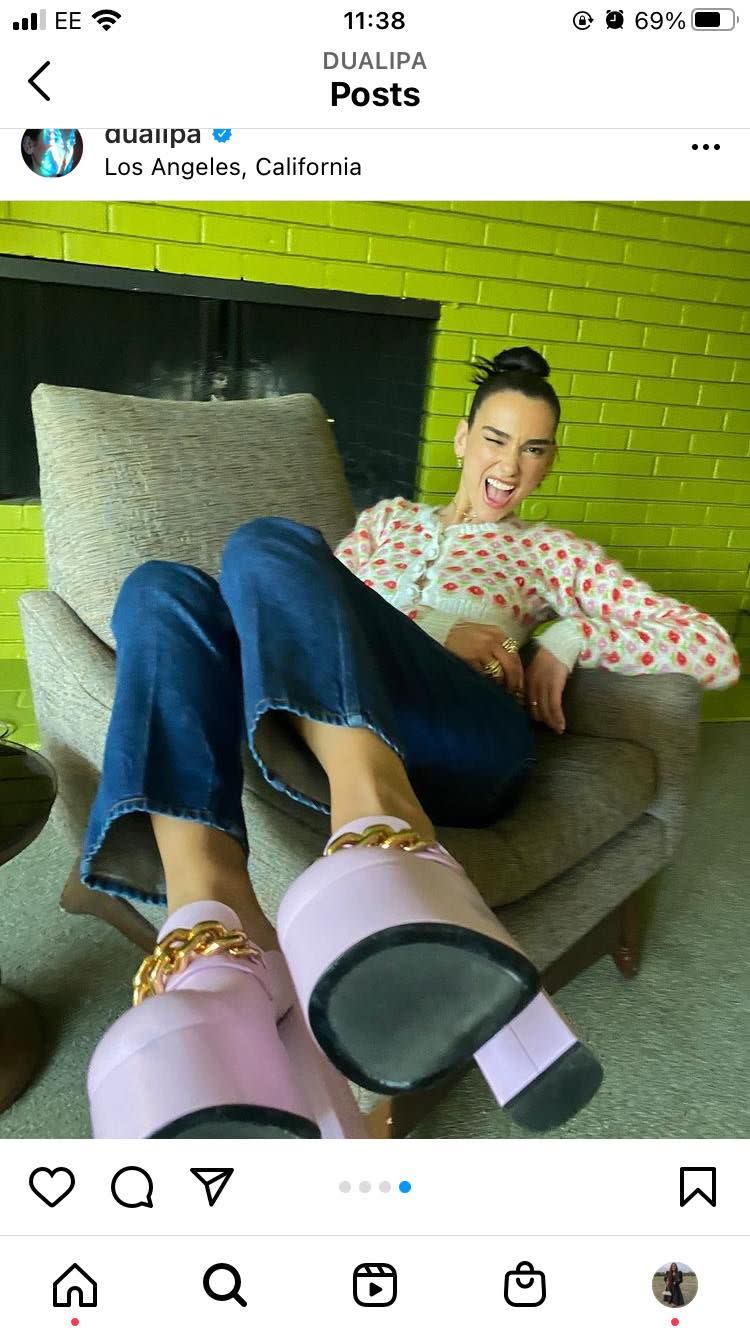 <p>In a carousel of images shared on her Instagram, Lipa posted pictures of various outfits she's worn while out promoting.</p><p>In this shot, Lipa looked playful in an Ashley Williams cardigan, Levi's jeans and Versace platforms. </p><p><a class="link " href="https://www.net-a-porter.com/en-gb/shop/search/versace" rel="nofollow noopener" target="_blank" data-ylk="slk:SHOP VERSACE NOW">SHOP VERSACE NOW</a></p>