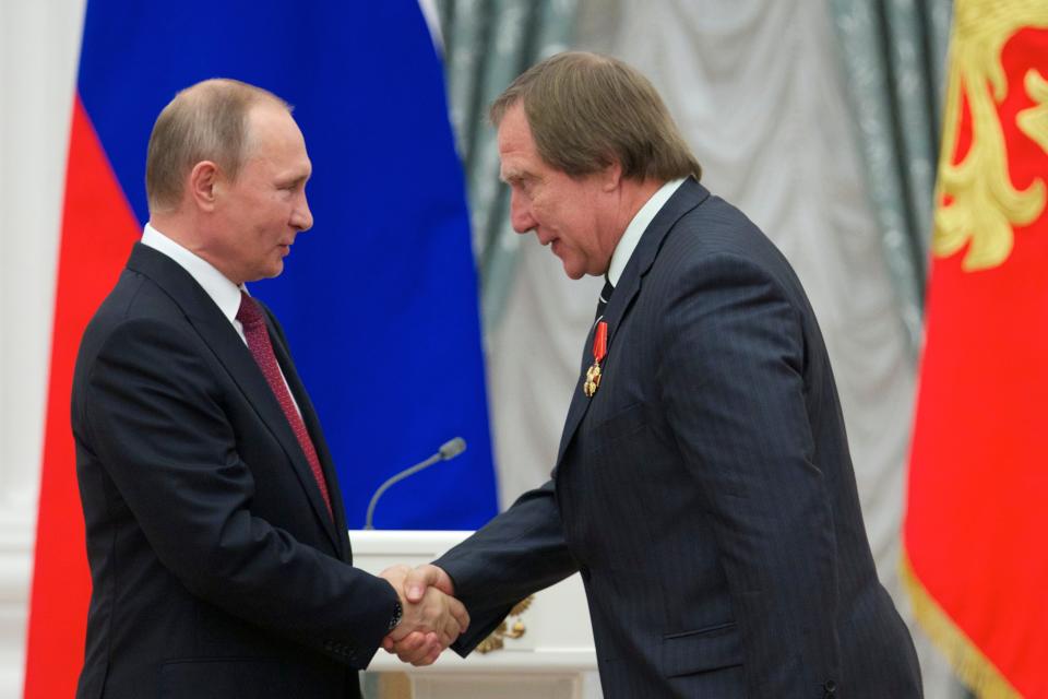 Russian President Vladimir Putin, left, presents a medal to Russian cellist Sergei Roldugin, during a ceremony in 2016.