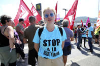 French activist Adele Lepoutre wears a sweeter reading "Stop discrimination" during a demonstration outside of a McDonald's restaurant, Thursday, Aug. 22, 2019 in Hendaye, southwestern France. The G-7 summit has for the first time co-opted the message of its protesters: Capitalism has led to damaging inequality, hurting the environment also harms the global economy, and a handful of rich countries can't be the only ones making decisions for the world. (AP Photo/Bob Edme)