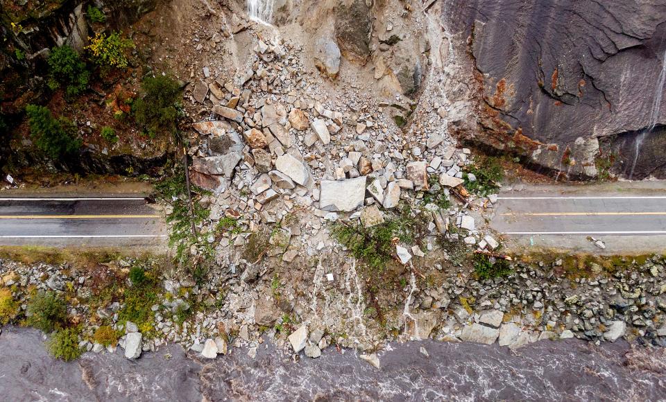 Rocks and vegetation cover Highway 70 following a landslide in the Dixie Fire zone on Sunday, Oct. 24, 2021, in Plumas County, Calif. Heavy rains blanketing Northern California created slide and flood hazards in land scorched during last summer's wildfires.