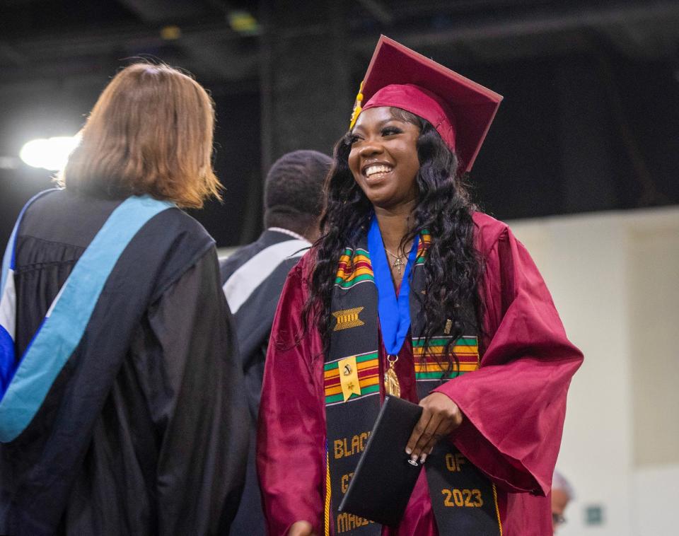 Marjorie K. Boadu, graduating with high honors, receives her diploma and smiles as her cheering section erupts during the Doherty Memorial High School commencement exercises at the DCU Center Wednesday.