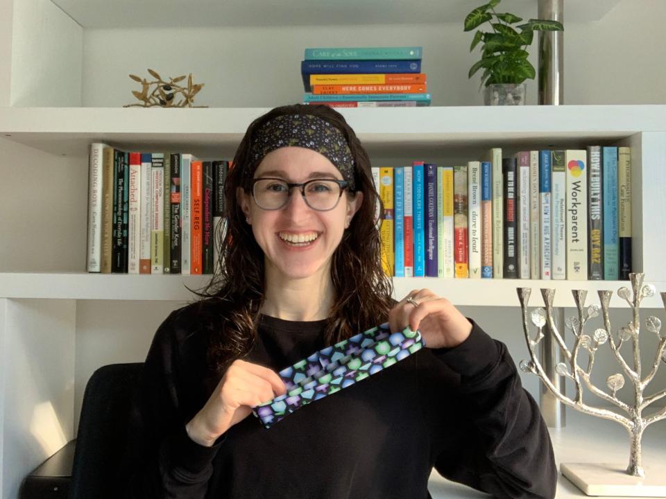 The author wearing a headband and holding another headband in front of her.