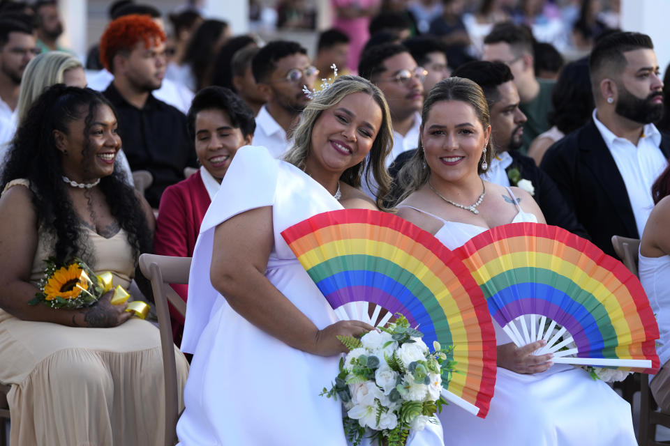 Hellen Graciela and Leidiane Alves pose for a photo as they wait to be joined in matrimony at a same-sex mass wedding ceremony organized to mark Pride Month in Goiania, Brazil, Friday, June 28, 2024. (AP Photo/Eraldo Peres)