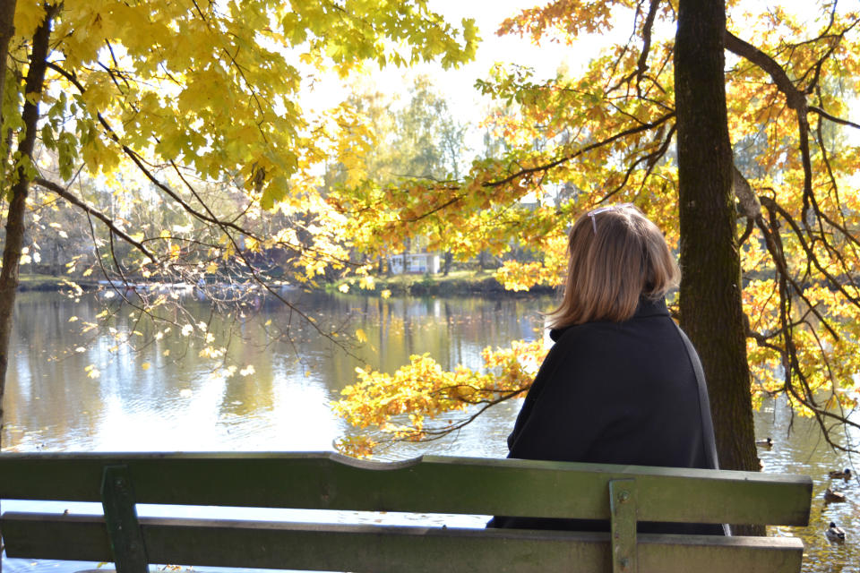 person on a bench looking out onto a lake