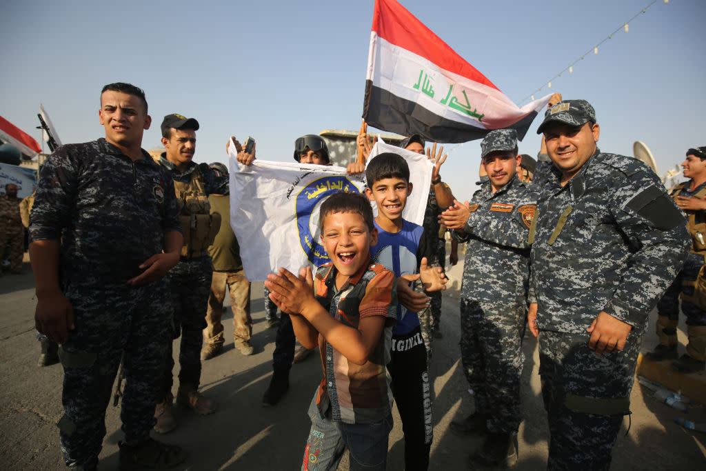 Iraqi federal police members and civilians celebrate in the Old City of Mosul on 9 July 2017 after the government's announcement of the "liberation" of the embattled city. Iraqi Prime Minister Haider al-Abadi's office said he was in "liberated" Mosul to congratulate "the heroic fighters and the Iraqi people on the achievement of the major victory": AFP/Getty Images