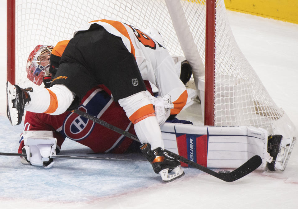 Montreal Canadiens goaltender Cayden Primeau, left, stops Philadelphia Flyers' Cam Atkinson during shootout NHL hockey game action in Montreal, Thursday, Dec. 16, 2021. (Graham Hughes/The Canadian Press via AP)