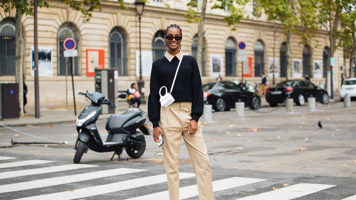 a person in a suit and sunglasses standing in a crosswalk