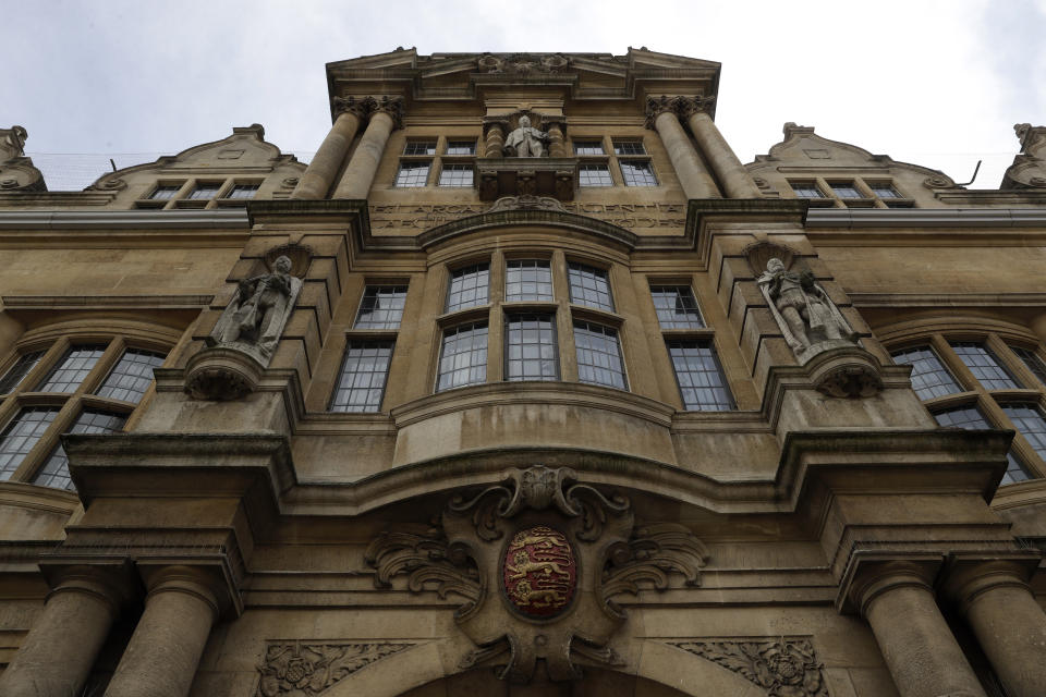 A statue of Cecil Rhodes, top centre, the controversial Victorian imperialist who supported apartheid-style measures in southern Africa stands mounted on the facade of Oriel College in Oxford, England, Wednesday, June 17, 2020. The governing body of Oriel College are meeting today to discuss the future of the statue. (AP Photo/Matt Dunham)